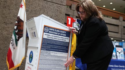 Une électrice dépose un vote dans une boîte prévue pour recevoir les courriers des américains qui optent pour le vote anticipé, à San José, en Californie, mardi 13 octobre 2020.&nbsp;&nbsp; (JUSTIN SULLIVAN / GETTY IMAGES NORTH AMERICA / AFP)