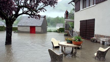 Une habitante regarde son jardin inond&eacute; &agrave; Loudenvielle (Hautes-Pyren&eacute;es), le 18 juin 2013. (LAURENT DARD / AFP)