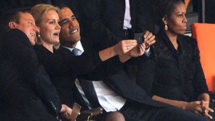 Le pr&eacute;sident am&eacute;ricain Barack Obama (D) et le Premier ministre britannique David Cameron (G) posent pour un selfie en compagnie de la Premi&egrave;re ministre danoise&nbsp;Helle Thorning Schmidt pendant la c&eacute;r&eacute;monie d'hommage &agrave; Nelson Mandela &agrave; Johannesbourg (Afrique du sud), le 10 d&eacute;cembre 2013. (ROBERTO SCHMIDT / AFP)