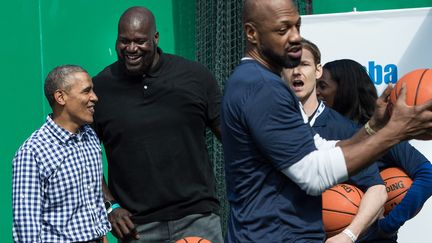 Dans cette photo d'archives prise le 28 mars 2016, le président américain Barack Obama plaisante avec l'ancien joueur de basket-ball de la NBA Shaquille O'Neal, reçu à la Maison Blanche à Washington.&nbsp; (NICHOLAS KAMM / AFP)