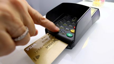 un terminal de paiement et une carte bancaire. (PATRICE LAPOIRIE / MAXPPP)