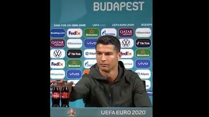 Cristiano Ronaldo retire deux bouteilles de Coca-Cola placées devant lui lors d'une conférence de presse de l'Euro, le 15 juin 2021. (CAPTURE D'ECRAN TWITTER)