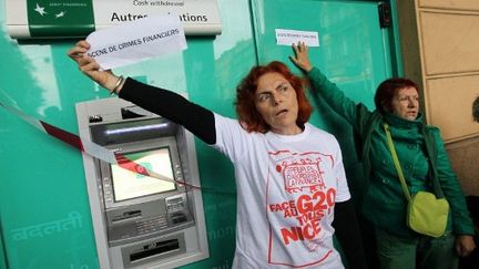 Des membres d'Attac, lisant une "scène de crime" devant une banque à Nice en novembre 2011 (AFP PHOTO / VALERY HACHE)