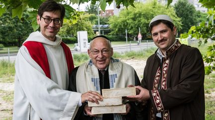 Le pasteur Gregor Hohberg, le rabbin Tovia Ben-Chorin et l'imam Kader Sanci posent la premi&egrave;re pi&egrave;re de leur projet de lieu de culte commun, &agrave; Berlin (Allemagne), le 3 juin 2014. (PAUL ZINKEN / MAXPPP)