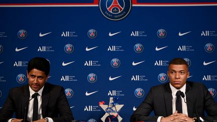 Nasser Al-Khelaïfi et Kylian Mbappé lors de la conférence de presse en marge de la prolongation de contrat de l'attaquant français, le 23 mai 2022. (FRANCK FIFE / AFP)