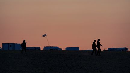 Des fêtards traversent des champs à l'arrivée du Teknival, un festival de musique techno gratuit, dans un champ à Villegongis, le 18 mai 2023. (GUILLAUME SOUVANT / AFP)