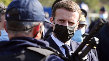 Emmanuel Macron échangeant avec un policier, le 5 novembre 2020. (GUILLAUME HORCAJUELO / POOL)