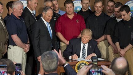 Donald Trump signe un décret qui met fin au plan Obama de réduction des émissions de CO2 dans les centrales à charbon (mars 2017). (AFP/ jim Watson )