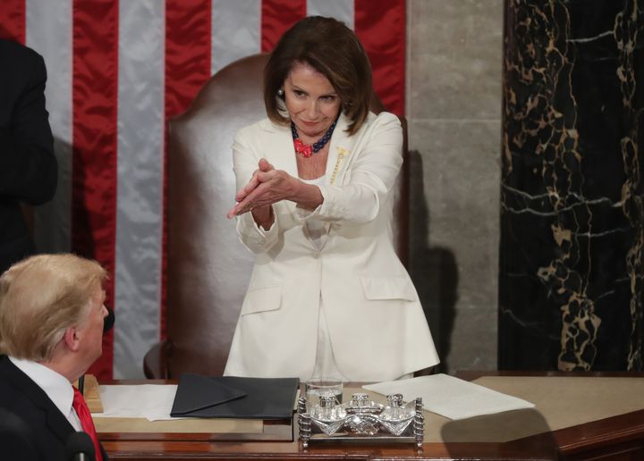 Vêtue de blanc en hommage aux suffragettes, Nancy Pelosi, présidente démocrate de la chambre des représentants, applaudit Donald Trump avant son discours sur l'état de l'Union, au Capitole, le 5 février 2019. (CHIP SOMODEVILLA / GETTY IMAGES NORTH AMERICA / AFP)