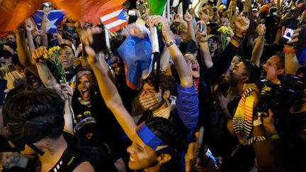 Explosion de joie chez les manifestants le 24 juillet 2019 à San Juan (Porto Rico), après l'annonce de la démission de Ricardo Rossello. (RICARDO ARDUENGO / AFP)