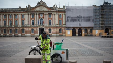 Un employé municipal nettoie la place du Capitole, désormais vide, le 17 mars 2020 à Toulouse (Haute-Garonne). (ALAIN PITTON / NURPHOTO / AFP)