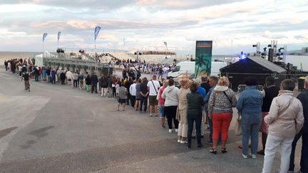 Le pass sanitaire est mis en place pour assister à un concert donné au théâtre de la mer, sur la plage du Canet-en-Roussillon. Une longue file d'attente se forme devant l'entrée, le temps de contrôler les QR codes des spectateurs.&nbsp; (SANDRINE ETOA-ANDEGUE / RADIO FRANCE)