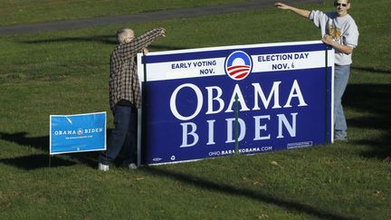 J-25 #TEAMOBAMA Des supporters de Barack Obama tentent d'attirer l'attention lors d'un meeting du candidat d&eacute;mocrate Mitt Romney &agrave; Lancaster (Ohio), le 12 octobre 2012. (MARY ALTAFFER / AP / SIPA)