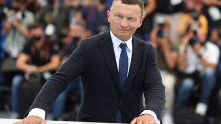 L'écrivain français Sylvain Tesson pose lors d'un photocall pour le film "La Panthère des neiges" dans le cadre de la sélection Cinéma pour le climat lors de la 74e édition du Festival de Cannes, le 14 juillet 2021. (VALERY HACHE / AFP)