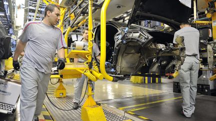 Des employ&eacute;s de PSA Peugeot Citro&euml;n travaillent sur la cha&icirc;ne de production de la DS4, le 2 mai 2011 &agrave; Mulhouse (Haut-Rhin). (SEBASTIEN BOZON / AFP)