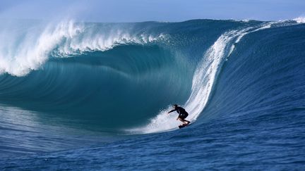 Un surfeur sur la vague géante Teahupoo à Tahiti, en septembre 2014. (GREGORY BOISSY / AFP)