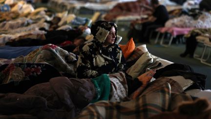 Une réfugiée ukrainienne a trouvé refuge dans le hall d'un stade de la capitale moldave&nbsp;Chisinau le 10 mars 2022. (MENAHEM KAHANA / AFP)