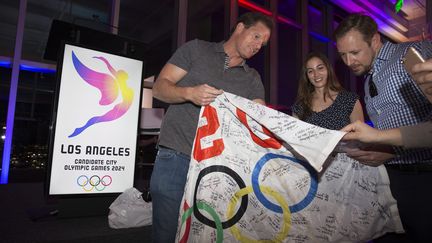 Athlètes et supporteurs avec le drapeau officiel de la présentation du Logo de Los Angeles-2024  (EUGENE GARCIA / EPA)