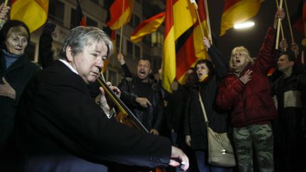 Le musicien Thomas Beckmann joue du violoncelle pour montrer son opposition &agrave; des manifestants anti-islam devant lui, le 12 janvier 2015, &agrave; D&uuml;sseldorf (Allemagne). (INA FASSBENDER / REUTERS)