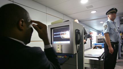 Un policier v&eacute;rifie le contenu d'un bagage &agrave; un poste de contr&ocirc;le de l'a&eacute;roport de Roissy. (THOMAS COEX / AFP)