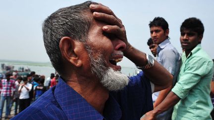 Un homme hurle de douleur &agrave;&nbsp;Munshigong&nbsp;(Bangladesh), le 13 mars 2012, apr&egrave;s le naufrage d'un ferry. (FABRICE COFFRINI / AFP)