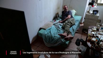 Un habitant de la rue d'Aubagne regarde la télévision, chez lui, à Marseille (Bouches-du-Rhône). (FRANCE 2)