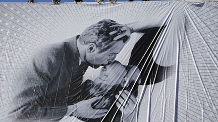 Des ouvriers installent l'affiche officielle du 66e festival de Cannes (Alpes-Maritimes)&nbsp;sur le palais des Festivals, le 13 mai 2013. (ERIC GAILLARD  / REUTERS)