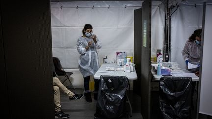 Une séance de vaccination contre le Covid-19, jeudi 14 janvier 2021, au Palais des sports de Lyon. (JEAN-PHILIPPE KSIAZEK / AFP)