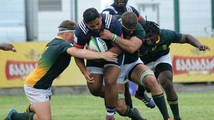 Les joueurs de l'équipe de France des moins de 20 ans pris dans la tenaille sud-africaine. (VANO SHLAMOV / AFP)