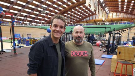 Theo Curin, sous la grande halle de l'Insep, en compagnie de&nbsp;Thierry Dumaine, en charge de la préparation physique. (FABRICE RIGOBERT / FRANCE INFO)