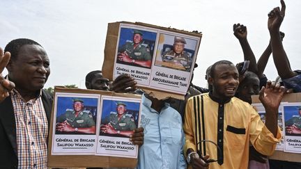 Des hommes brandissent des pancartes en faveur des putschistes à Niamey (Niger), le 6 août 2023. (AFP)