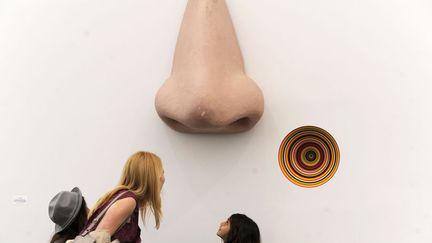 Des visiteurs observent "Vortex Eau de Parfum", une&nbsp;oeuvre de l'artiste Jim Lampie expos&eacute;e &agrave; la Frieze Art Fair de New York, le 5 mai 2012. (KEITH BEDFORD / REUTERS)