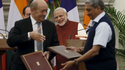 A New Delhi, le 23 septembre 2016... après la signature du contrat pour la vente de Rafale à l'Inde. Le ministre de la Défense français, Jean-Yves Le Drian, s'apprête à serrer la main de son homologue indien, Manohar Parrikar. En arrière-plan: à gauche, on aperçoit le président français, François Hollande, et à droite, le Premier ministre indien, Narendra Modi. Tous les deux tout sourire.  ( REUTERS - Adnan Abidi)