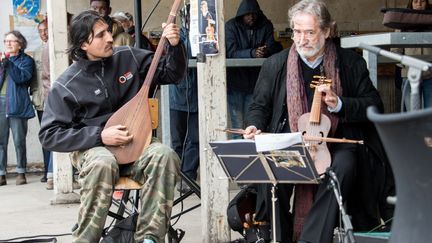 A Calais, Jordi Savall joue avec Ismaël, un jeune Afghan (16 avril 2016)
 (Denis Charlet / AFP)