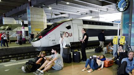 Des voyageurs attendent leur train à la gare Montparnasse, à Paris, le 27 juillet 2018. (GERARD JULIEN / AFP)