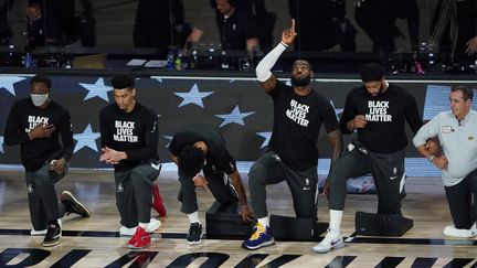 Les Los Angeles Lakers d'Anthony Davis (2e en partant de la droite) et LeBron James (3e en partant de la droite) posent le genou à terre pour le mouvement BlackLivesMatter. (POOL / GETTY IMAGES NORTH AMERICA)