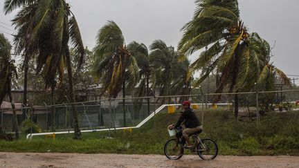 Un homme fait du vélo à Bilwi, Puerto Cabezas, au Nicaragua, le 16 novembre 2020 alors que l'ouragan Iota traverse les Caraïbes en direction de la frontière entre le Nicaragua et le Honduras. (STR / AFP)