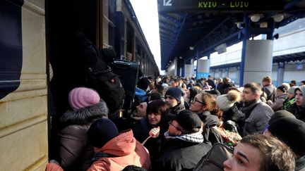 Des réfugiés ukrainiens tentent d'embarquer à bord d'un train à la gare centrale de Kiev le 4 mars 2022. (SERGEI CHUZAVKOV / AFP)