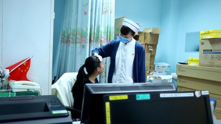 Une infirmière examine une jeune patiente dans un hôpital de Pékin, le 11 janvier 2018.&nbsp; (ZHANG YUWEI / XINHUA / AFP)