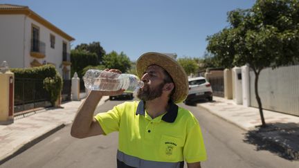 Un agent d'entretien se désaltère dans une rue de Ronda, dans le sud de l'Espagne, le 15 juillet 2023. (JORGE GUERRERO / AFP)