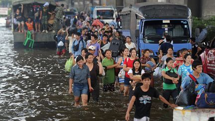 Ces inondations sans pr&eacute;c&eacute;dent provoquent une exode des populations menac&eacute;es. (POMCHAI KITTIWONGSAKUL / AFP)