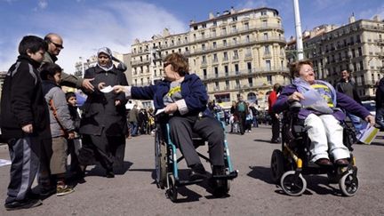 Des handicapés en train de distribuer des tracts sur le Vieux-Port à Marseille le 27 mars 2010 (AFP - ANNE-CHRISTINE POUJOULAT)