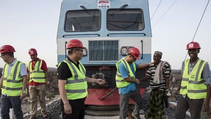 Un riverain salue le personnel chinois et africain qui travaille sur la ligne de chemin de fer Addis-Abeba-Djibouti durant des essais à Addis Abeba, la capitale de l'Ethiopie, le 28 septembre 2016. La première ligne de chemin de fer électrifiée jamais construite entre deux pays africains est l'œuvre d'entreprises chinoises. Elle a été mise en service le 5 octobre 2016.  (Qin bin / Imaginechina)