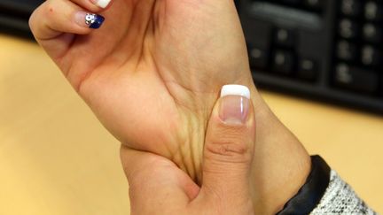 Une femme souffre du syndrome du canal carpien au bureau. (THIERRY GACHON / MAXPPP)