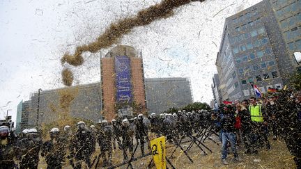 Un jet de foin sur la police anti-&eacute;meutes devant le si&egrave;ge de la Commission europ&eacute;enne lundi 7 septembre 2015. (EMMANUEL DUNAND / AFP)