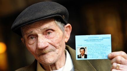 Raymond Gurême, en 2010, alors agé de 85 ans, il montre sa carte d'interné. Il a été arrêté et interné avec sa famille dans les camps pour "nomades" lorsqu'il avait 15 ans.
 (AFP / BERTRAND GUAY)