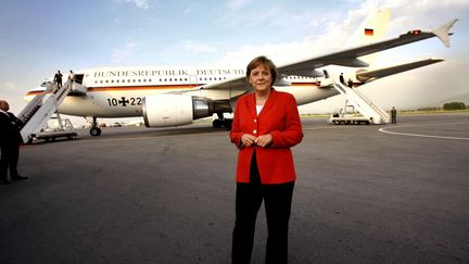 La chanceli&egrave;re allemande, Angela Merkel, pose devant son avion, le 23 mai 2006, &agrave; l'a&eacute;roport d'Almaty (Kazakhstan). (MICHAEL KAPPELER / AFP)