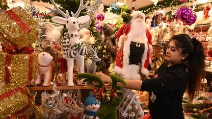 Une vendeuse place des décorations de Noël dans son magasin de Chennai (Inde), le 20 décembre 2021.&nbsp; (ARUN SANKAR / AFP)