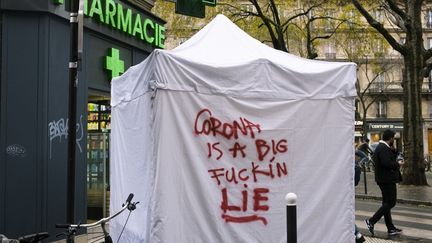 "Le coronavirus est un putain de gros mensonge". Un graffiti sur la tente d'un point de test antigénique à Paris, le 19 décembre 2020. (JEANNE FOURNEAU / HANS LUCAS / AFP)