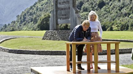 La présidente chilienne, Michelle Bachelet, signe un document sur une donation de terres aux côtés de la veuve de Douglas Tompkins, Kristine McDivitt, le 15 mars 2017, à Parque Pumalin (Chili). (PRESIDENCIA DE CHILE / AFP)